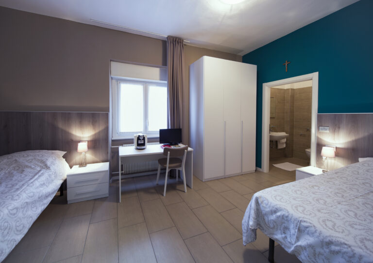 Stanza da letto con due letti, scrvania, armadio e bagno