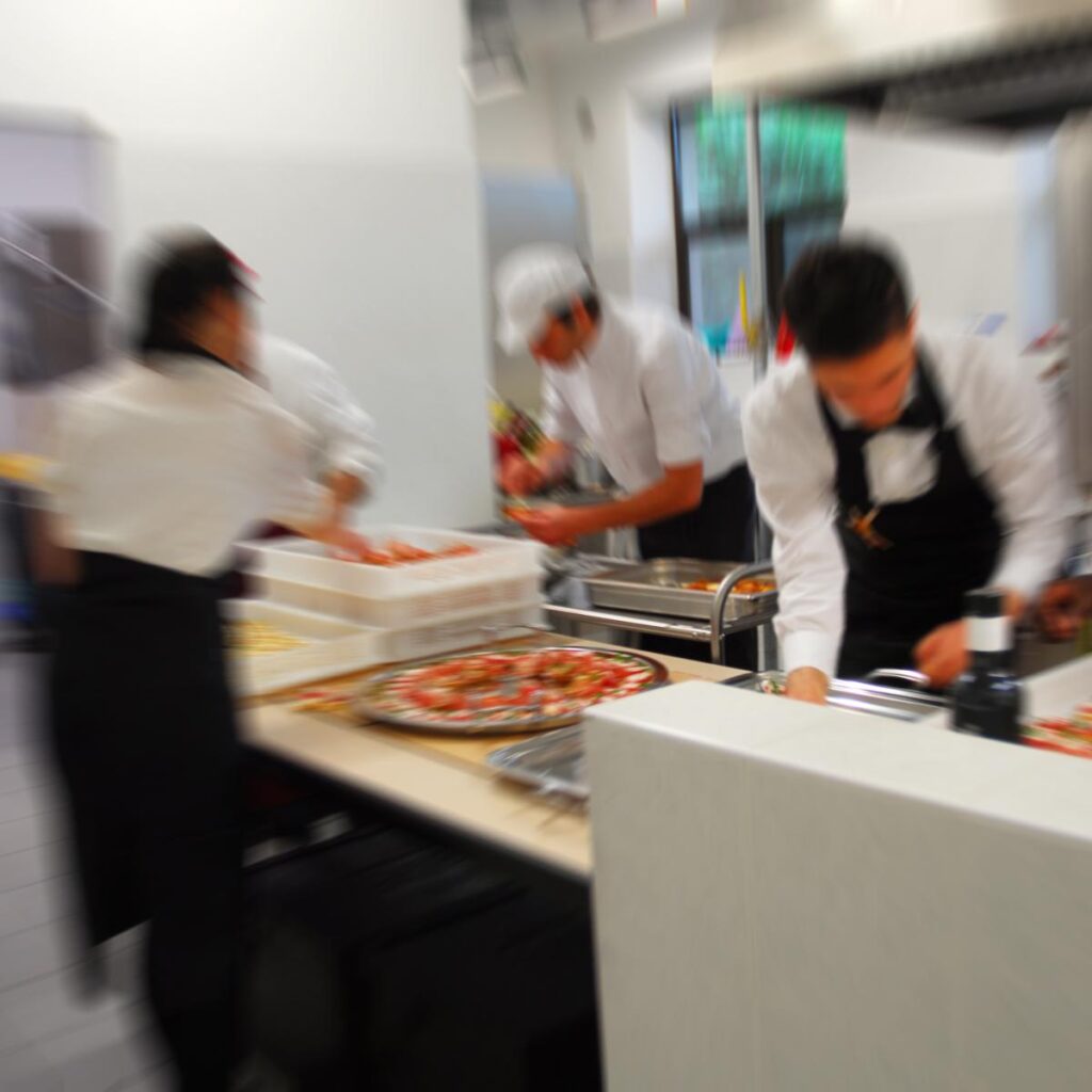 operatori in cucina intenti a preparare i piatti